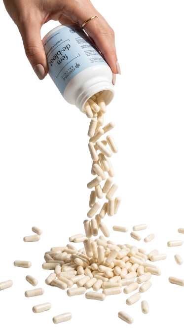 Fem De-Bloat capsules pouring from bottle — women's bloat support supplement