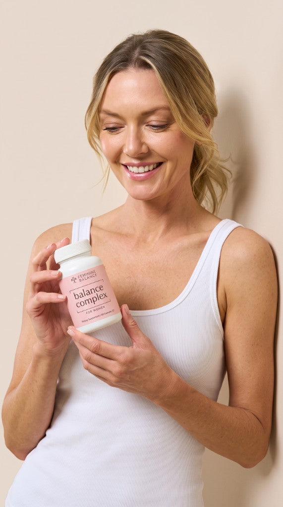 Woman holding Feminine Balance Balance Complex supplement bottle
